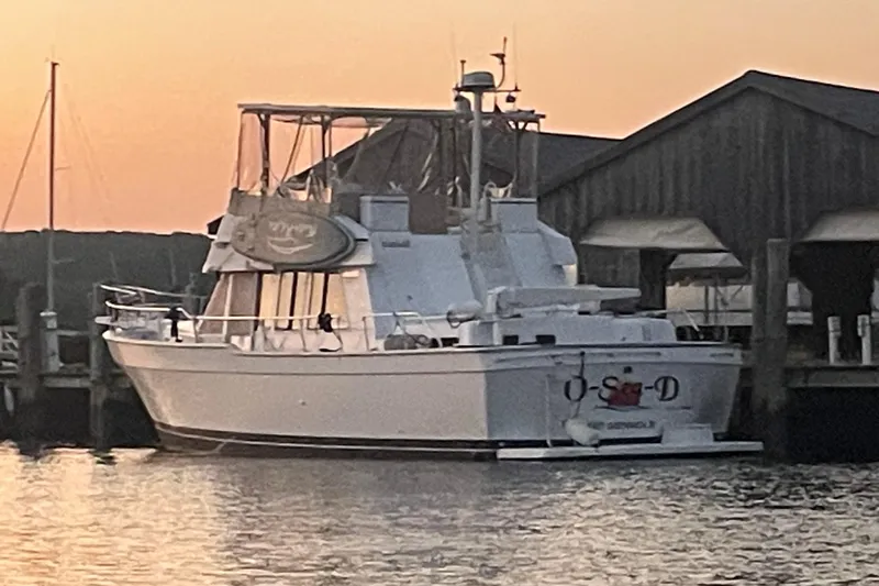  Yacht Photos Pics 1999 Mainship 430 Trawler docked at sunset near a wooden boathouse.