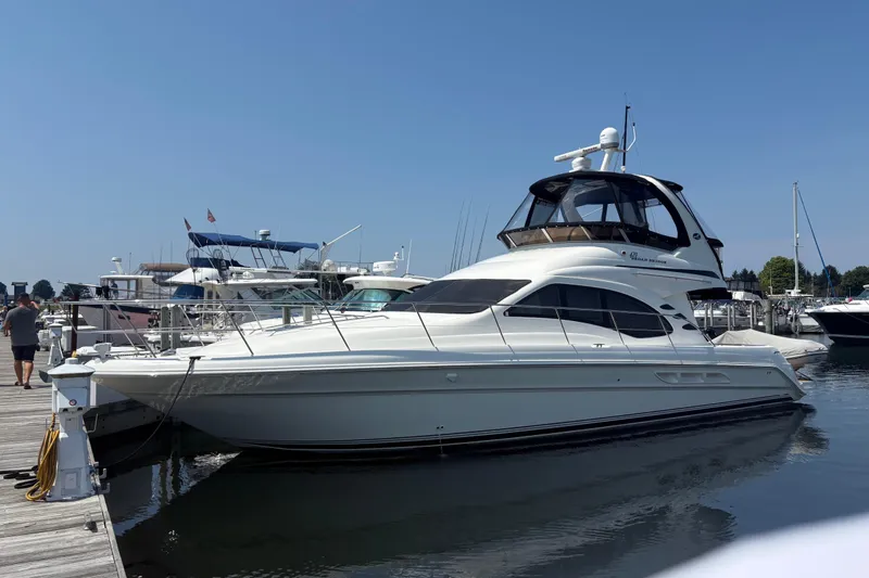 Our Alibi Yacht Photos Pics 2004 Sea Ray 420 Sedan Bridge yacht docked at marina under clear blue sky.