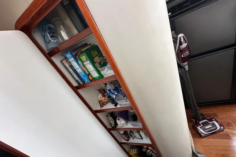 Our Alibi Yacht Photos Pics Storage shelves with snacks and cleaning supplies on a 2004 Sea Ray 420 Sedan Bridge.