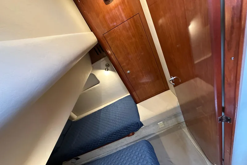 Our Alibi Yacht Photos Pics Interior cabin of 2004 Sea Ray 420 Sedan Bridge with twin beds and wooden cabinetry.