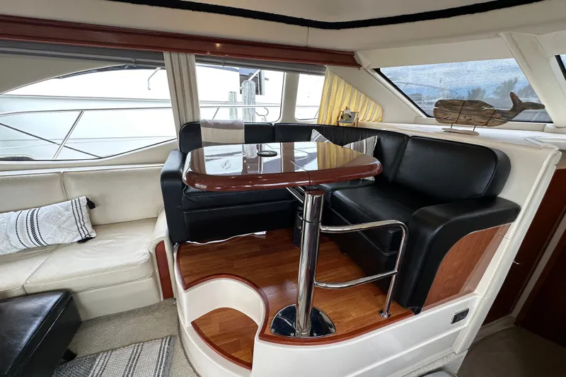 Our Alibi Yacht Photos Pics Luxurious interior of 2004 Sea Ray 420 Sedan Bridge with elegant seating and table.