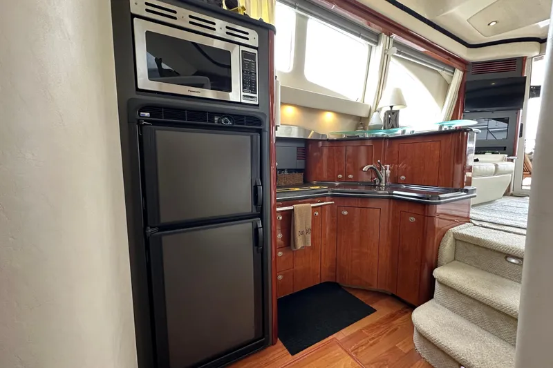 Our Alibi Yacht Photos Pics Luxurious 2004 Sea Ray 420 Sedan Bridge yacht kitchen with modern appliances and elegant wood cabinetry.