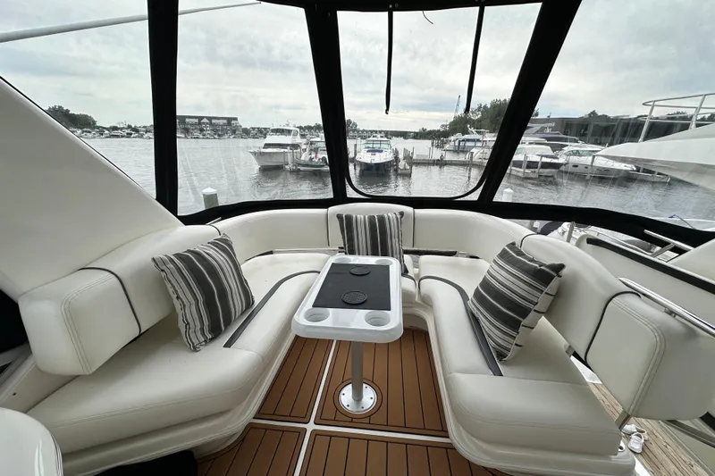 Our Alibi Yacht Photos Pics Luxurious 2004 Sea Ray 420 Sedan Bridge yacht interior with striped cushions and marina view.