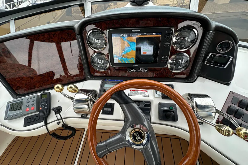 Our Alibi Yacht Photos Pics 2004 Sea Ray 420 Sedan Bridge helm with navigation system and wooden steering wheel.