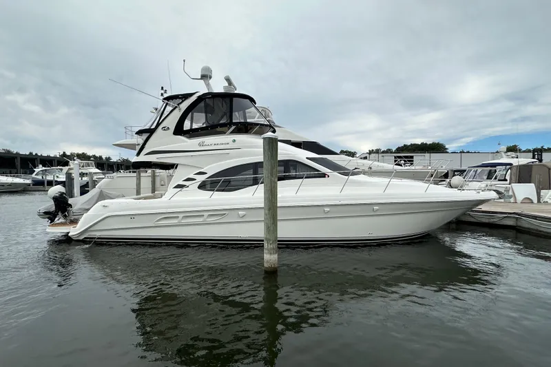 Our Alibi Yacht Photos Pics 2004 Sea Ray 420 Sedan Bridge yacht docked at marina under cloudy sky.
