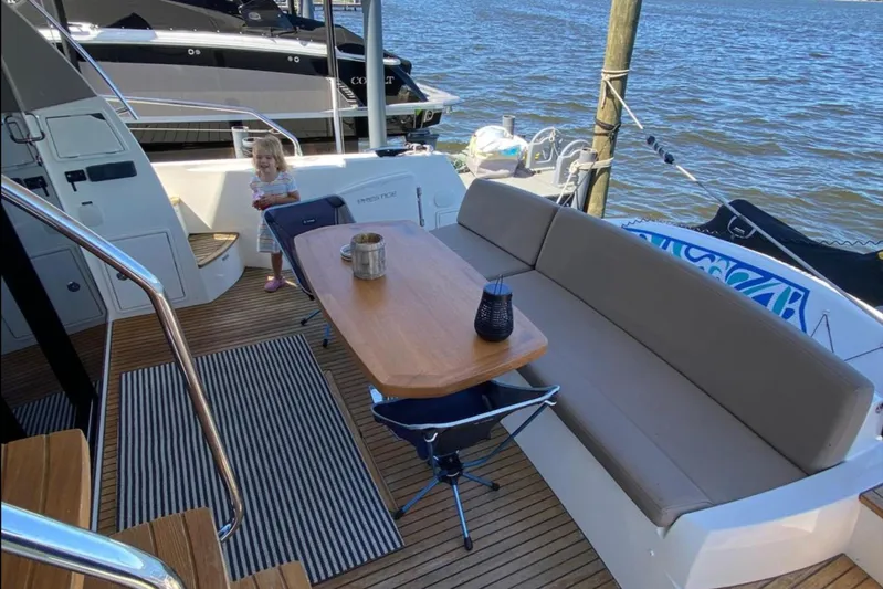  Yacht Photos Pics Prestige 500 yacht deck, 2012 model, with seating area and child by the water.