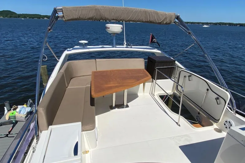  Yacht Photos Pics Flybridge of 2012 Prestige 500 yacht with seating and table, overlooking calm waters.