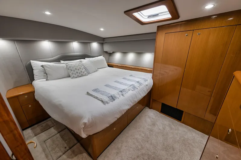  Yacht Photos Pics Luxurious bedroom interior of a 2001 Viking 65 yacht with elegant wood finishes.