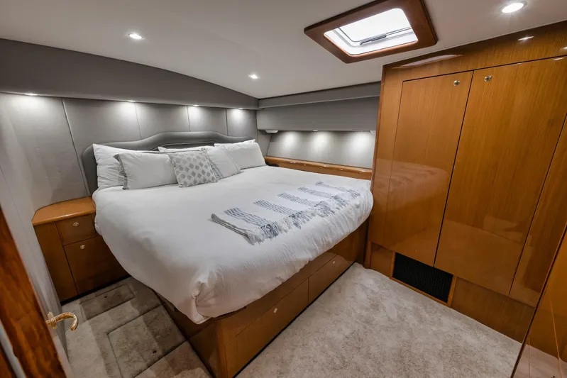  Yacht Photos Pics Luxurious bedroom interior of a 2001 Viking 65 yacht with elegant wood finishes.