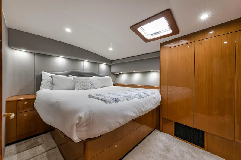  Yacht Photos Pics Luxurious bedroom interior of a 2001 Viking 65 yacht with elegant wood finishes.