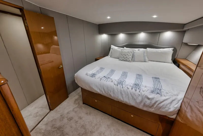  Yacht Photos Pics Luxurious bedroom interior of 2001 Viking 65 yacht with cozy bedding and modern lighting.