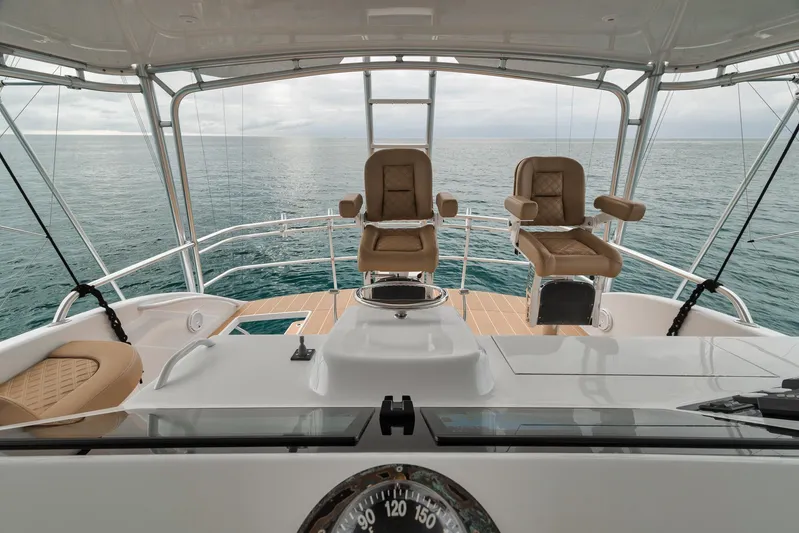  Yacht Photos Pics Bridge view of 2001 Viking 65 yacht with ocean backdrop and helm chairs.