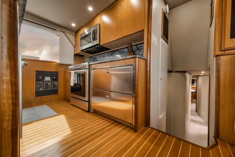  Yacht Photos Pics Luxurious kitchen interior of a 2001 Viking 65 yacht with modern appliances and wood flooring.