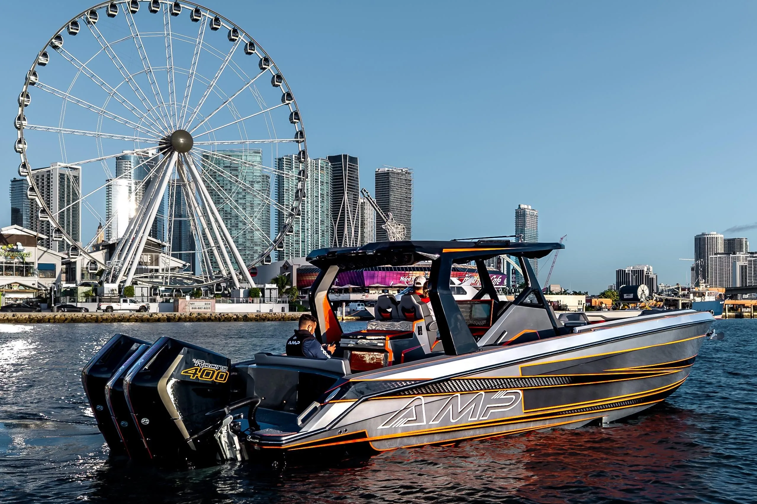 Modern AMP 333 boat cruising near city skyline and Ferris wheel, 2026 model.