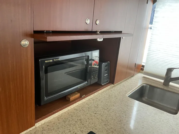  Yacht Photos Pics Microwave in 1984 Hatteras 52 Convertible yacht kitchen with wood cabinetry and sink.