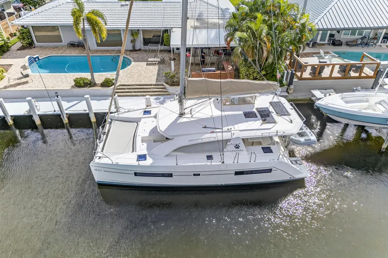  Yacht Photos Pics 2017 Leopard 40 catamaran docked near waterfront homes with pools and palm trees.