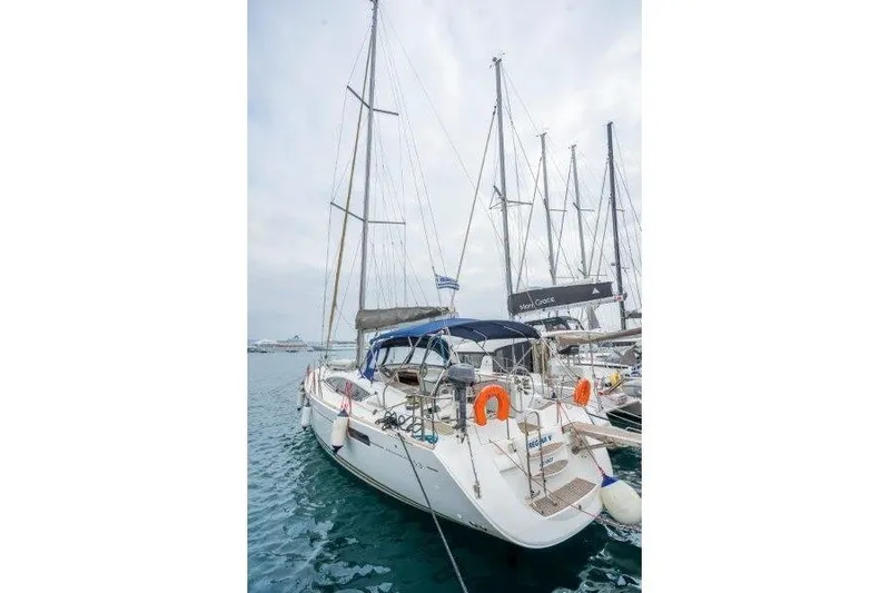  Yacht Photos Pics 2010 Jeanneau 53 sailboat docked in marina, featuring blue canopy and lifebuoys.