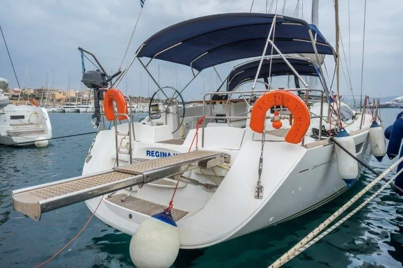  Yacht Photos Pics 2010 Jeanneau 53 yacht docked in marina, featuring dual steering wheels and safety equipment.