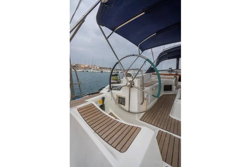  Yacht Photos Pics 2010 Jeanneau 53 yacht cockpit with steering wheel and wooden deck, docked at marina.