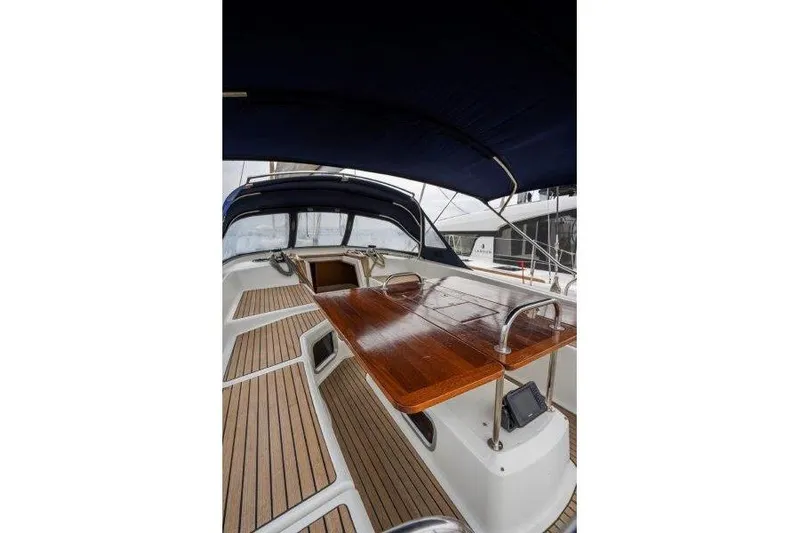  Yacht Photos Pics Cockpit view of 2010 Jeanneau 53 sailboat with wooden table and seating.