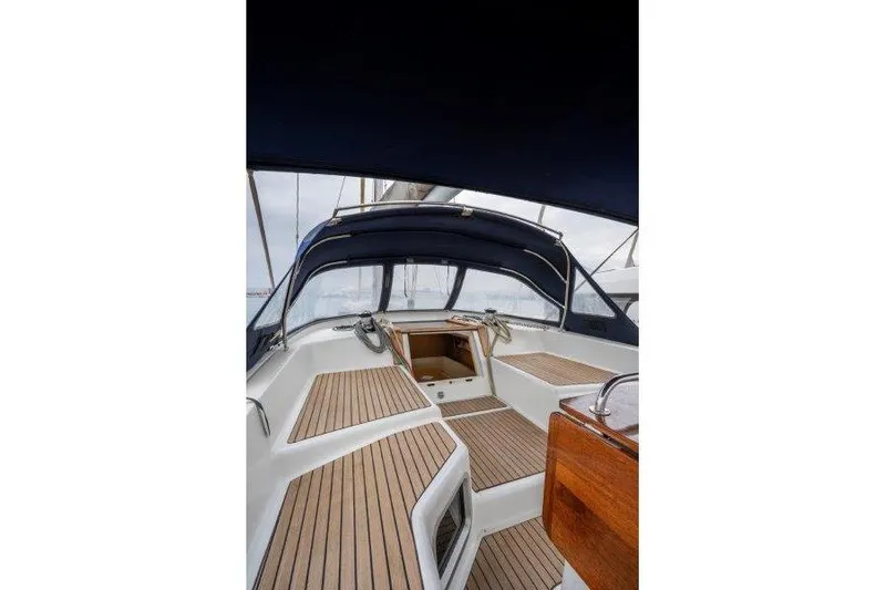  Yacht Photos Pics 2010 Jeanneau 53 sailboat cockpit with teak flooring and blue canopy.