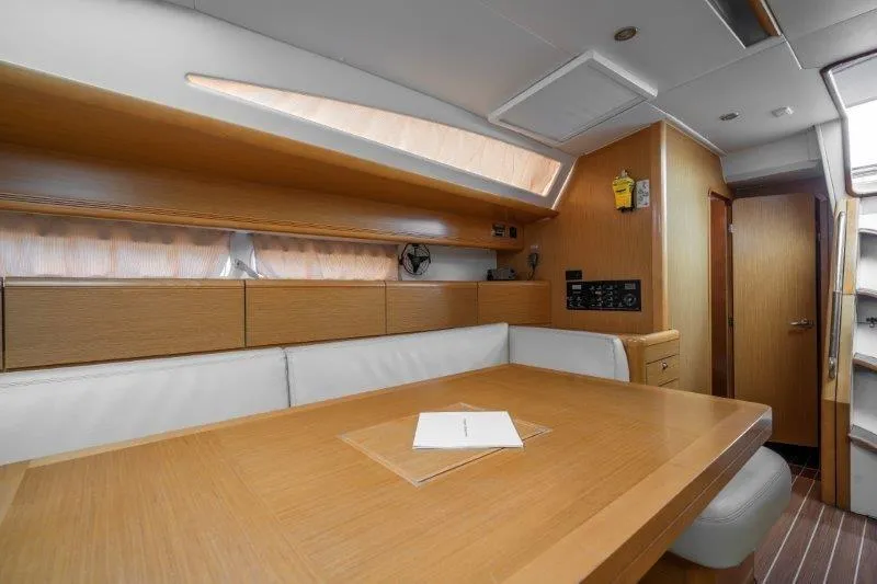  Yacht Photos Pics Interior of 2010 Jeanneau 53 yacht with wooden table and seating area.