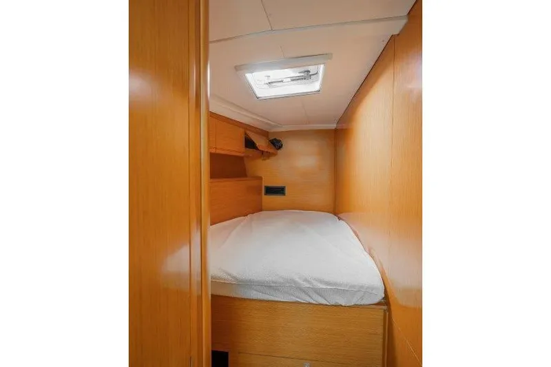  Yacht Photos Pics Cozy cabin interior of 2010 Jeanneau 53 yacht with wooden finish and overhead hatch.