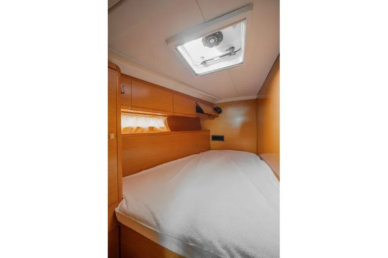  Yacht Photos Pics Cozy cabin interior of 2010 Jeanneau 53 yacht with wooden finish and overhead hatch.