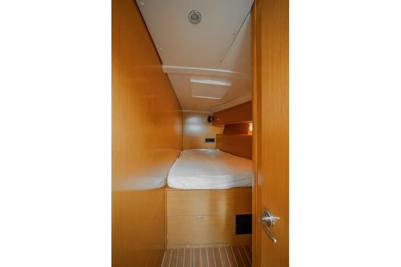  Yacht Photos Pics Interior cabin of 2010 Jeanneau 53 yacht with wooden finish and cozy bed.