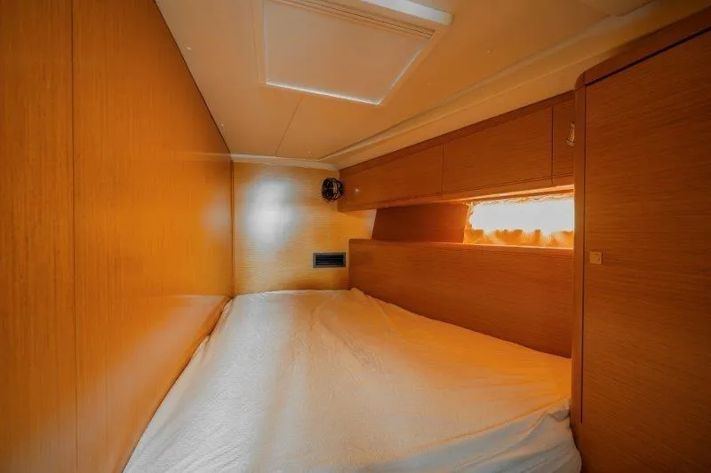  Yacht Photos Pics Cozy cabin interior of 2010 Jeanneau 53 yacht with wooden finish and soft lighting.