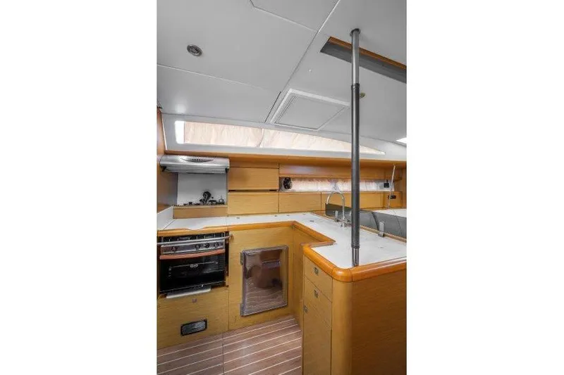  Yacht Photos Pics Interior of 2010 Jeanneau 53 yacht kitchen with modern appliances and wooden cabinetry.