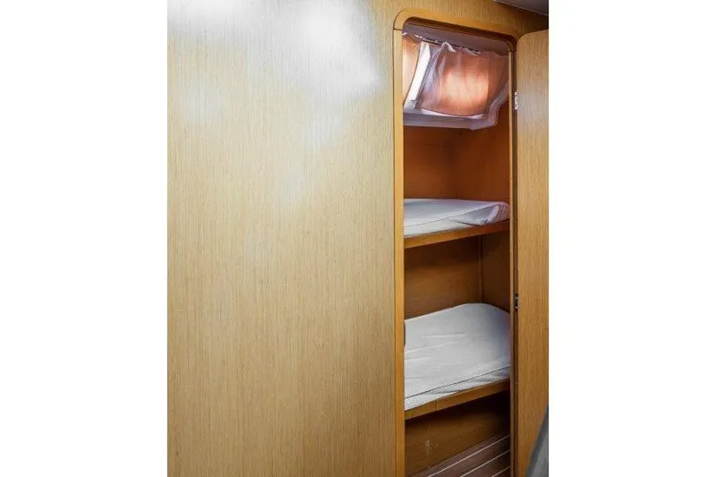  Yacht Photos Pics Interior of 2010 Jeanneau 53 yacht showing wooden bunk beds and storage.