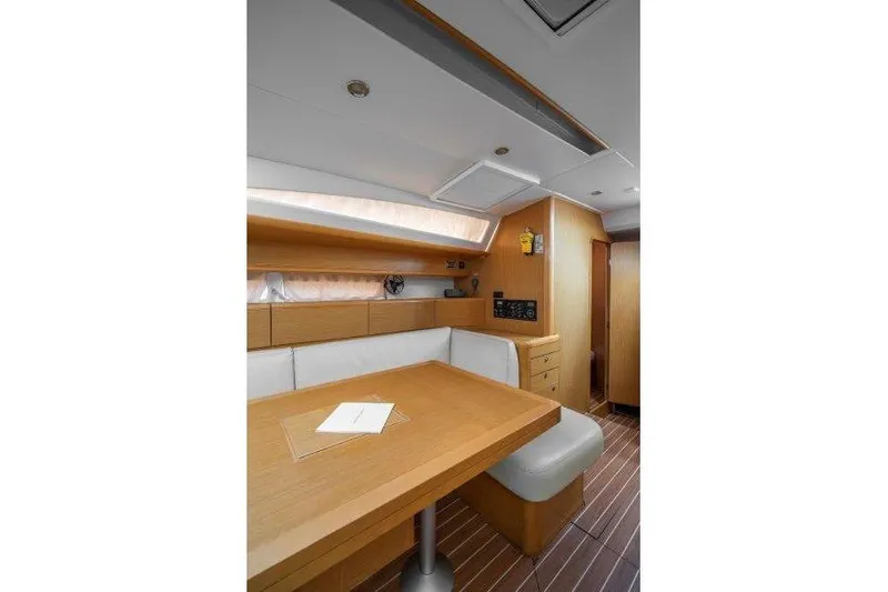  Yacht Photos Pics Interior of 2010 Jeanneau 53 yacht with wooden table and white seating.