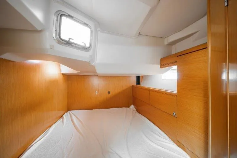  Yacht Photos Pics Interior cabin of 2010 Jeanneau 53 yacht with wooden finish and bedding.