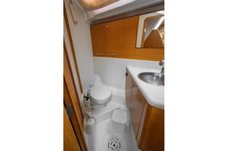  Yacht Photos Pics Bathroom interior of 2010 Jeanneau 53 yacht with sink, toilet, and wooden cabinetry.