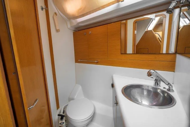  Yacht Photos Pics 2010 Jeanneau 53 yacht bathroom with modern sink, toilet, and wooden cabinetry.