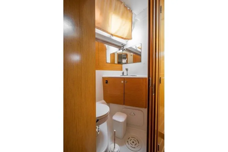  Yacht Photos Pics Compact bathroom in a 2010 Jeanneau 53 yacht, featuring wood cabinetry and modern fixtures.