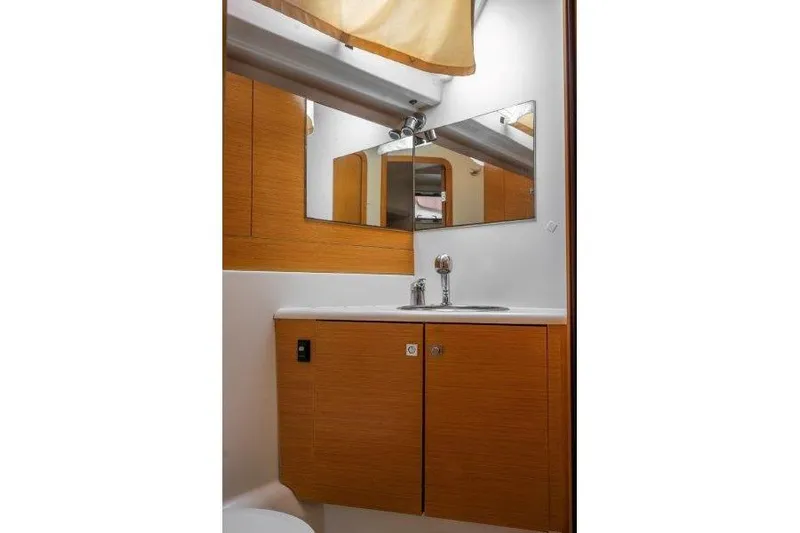  Yacht Photos Pics Bathroom interior of 2010 Jeanneau 53 yacht with wooden cabinets and mirror.