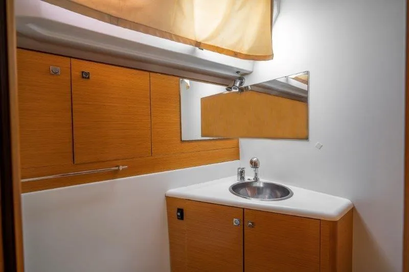  Yacht Photos Pics 2010 Jeanneau 53 yacht bathroom with wooden cabinets and stainless steel sink.