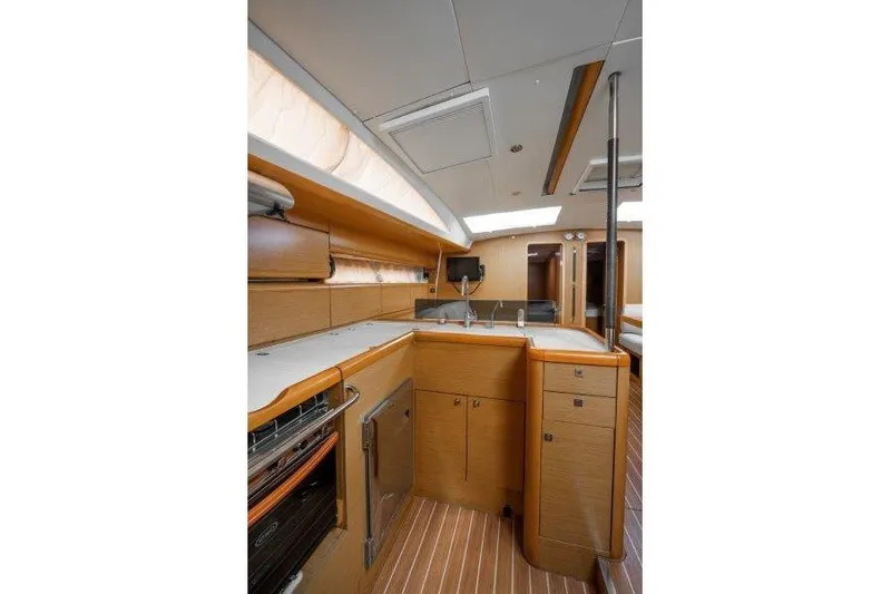 Yacht Photos Pics Interior of 2010 Jeanneau 53 yacht featuring modern kitchen with wood cabinetry and sleek design.