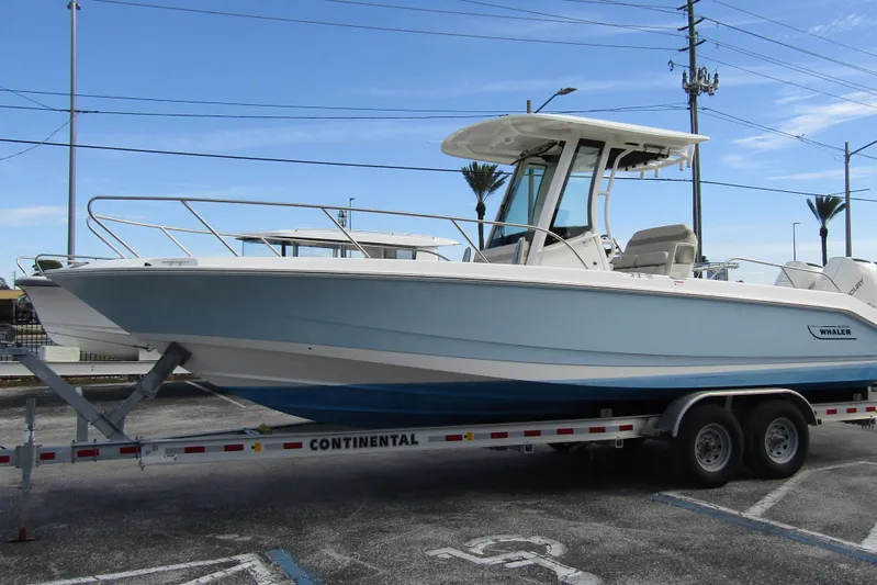  Yacht Photos Pics 2023 Boston Whaler 280 Dauntless boat on trailer, parked outdoors.