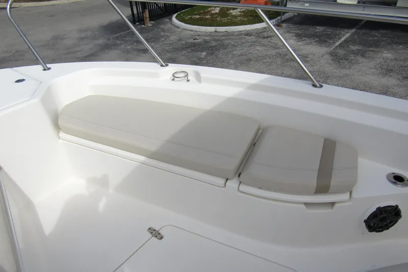  Yacht Photos Pics 2023 Boston Whaler 280 Dauntless boat seating area with cushioned bench and stainless steel railing.