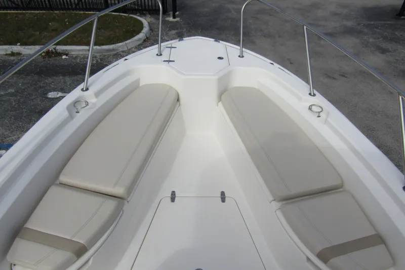  Yacht Photos Pics 2023 Boston Whaler 280 Dauntless boat interior with cushioned seating and stainless steel railings.