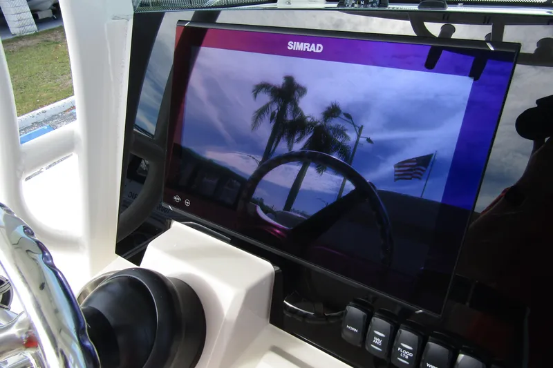  Yacht Photos Pics Simrad display on 2023 Boston Whaler 280 Dauntless, showing palm trees and American flag reflection.