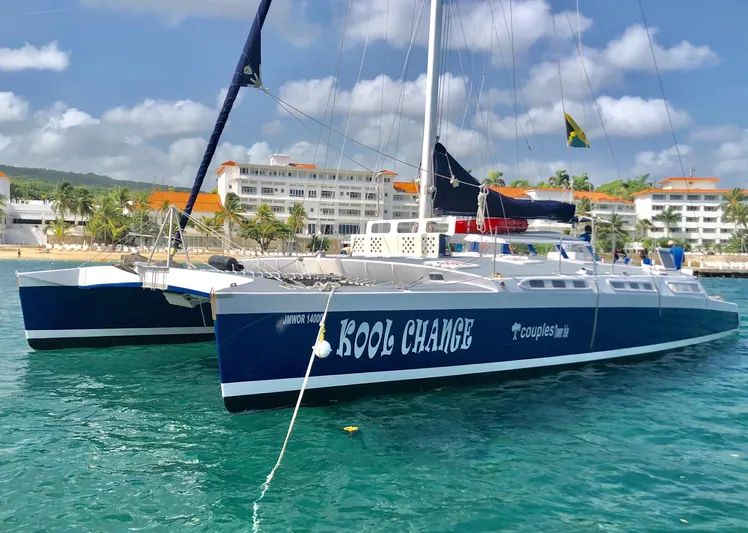 Kool Change Yacht Photos Pics 1984 Custom Spronk Day Charter Catamaran Kool Change docked near a tropical beach resort.