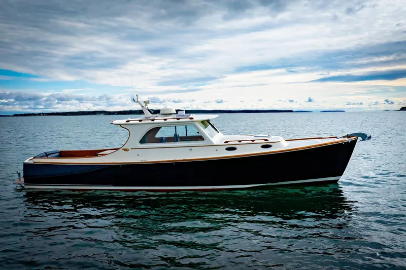 Lab Adore Yacht Photos Pics 2003 Hinckley Picnic Boat EP on calm water under cloudy sky.