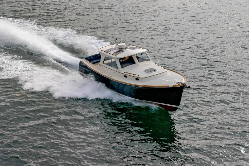 Lab Adore Yacht Photos Pics 2003 Hinckley Picnic Boat EP cruising on open water, showcasing sleek design and performance.