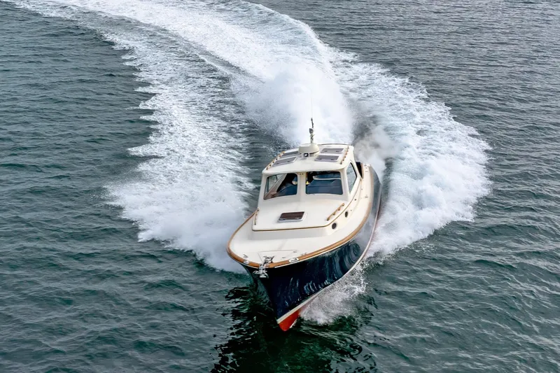 Lab Adore Yacht Photos Pics 2003 Hinckley Picnic Boat EP cruising on open water, creating a dynamic wake.