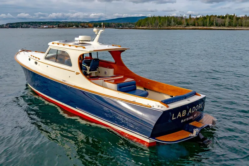 Lab Adore Yacht Photos Pics 2003 Hinckley Picnic Boat EP on serene water with scenic background.