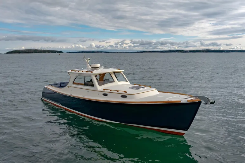 Lab Adore Yacht Photos Pics 2003 Hinckley Picnic Boat EP on calm waters under cloudy sky.